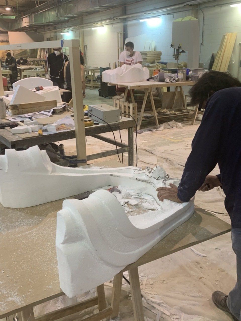 Un hombre está trabajando en un trozo de poliestireno en una fábrica.