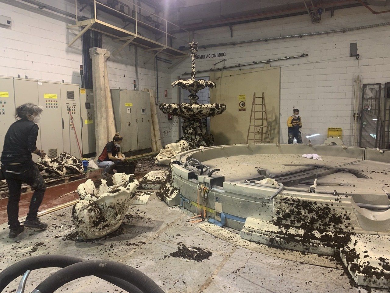 Un grupo de personas está trabajando en una fuente en un edificio.