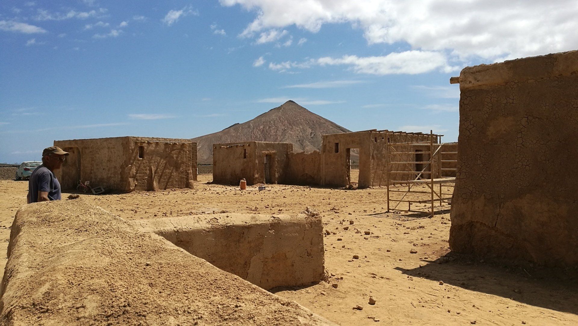 Un grupo de edificios en el desierto con una montaña al fondo.
