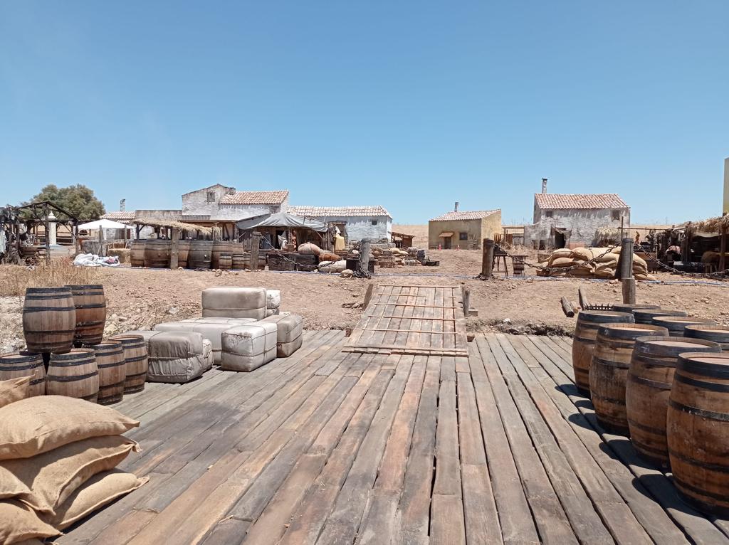 Una plataforma de madera con barriles y bolsas encima.