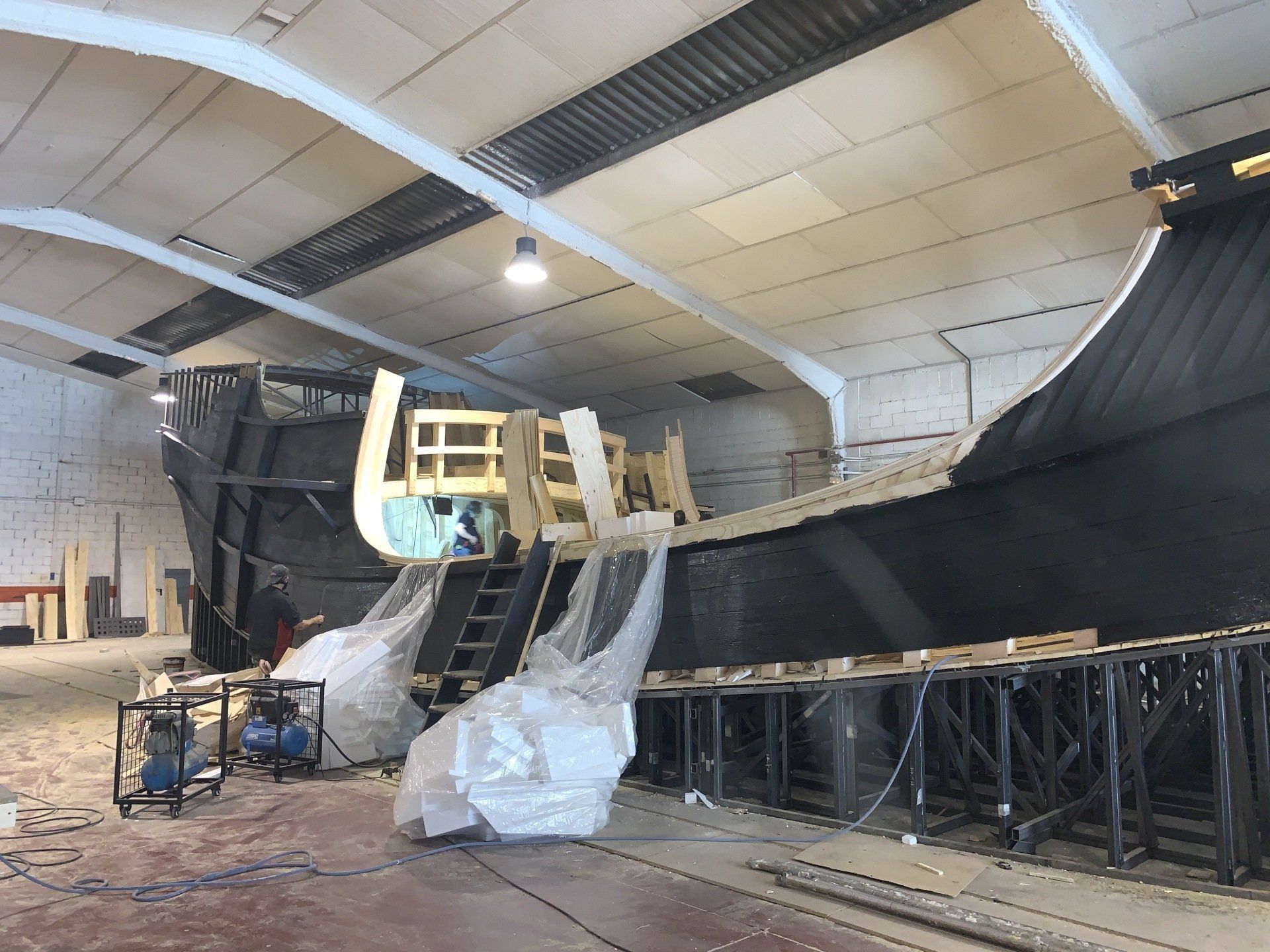 Se está construyendo un gran barco en un almacén.