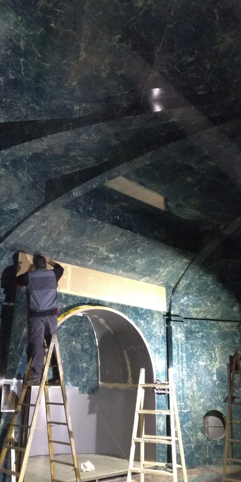 Un hombre está de pie en una escalera en una habitación.