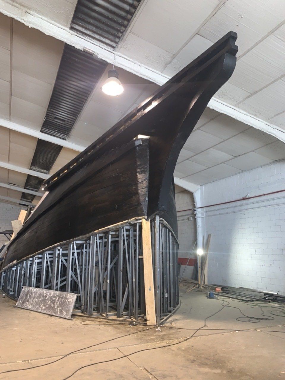 Se está construyendo un gran barco negro en un almacén.