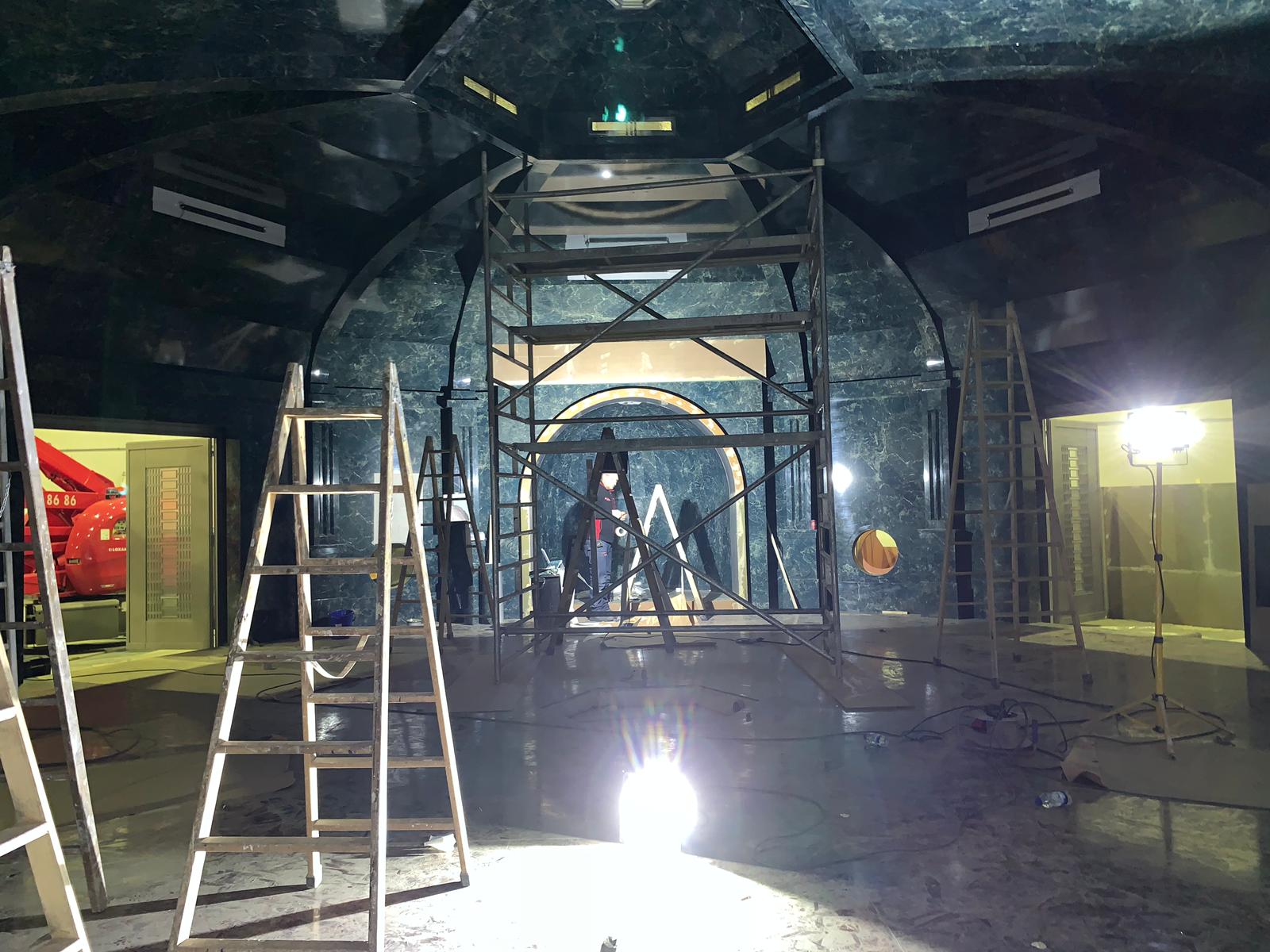 Un hombre está de pie en una escalera en una habitación oscura.