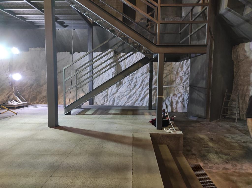 Una persona está parada al lado de un conjunto de escaleras en un edificio.