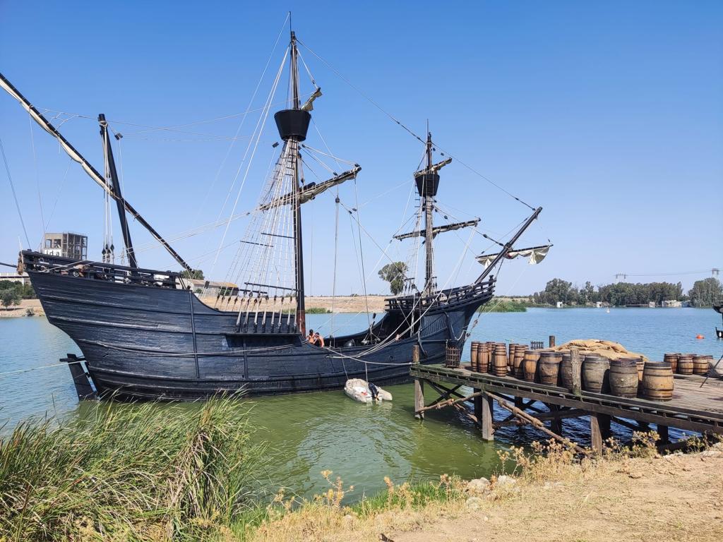 Un barco pirata está atracado en el agua junto a un muelle.