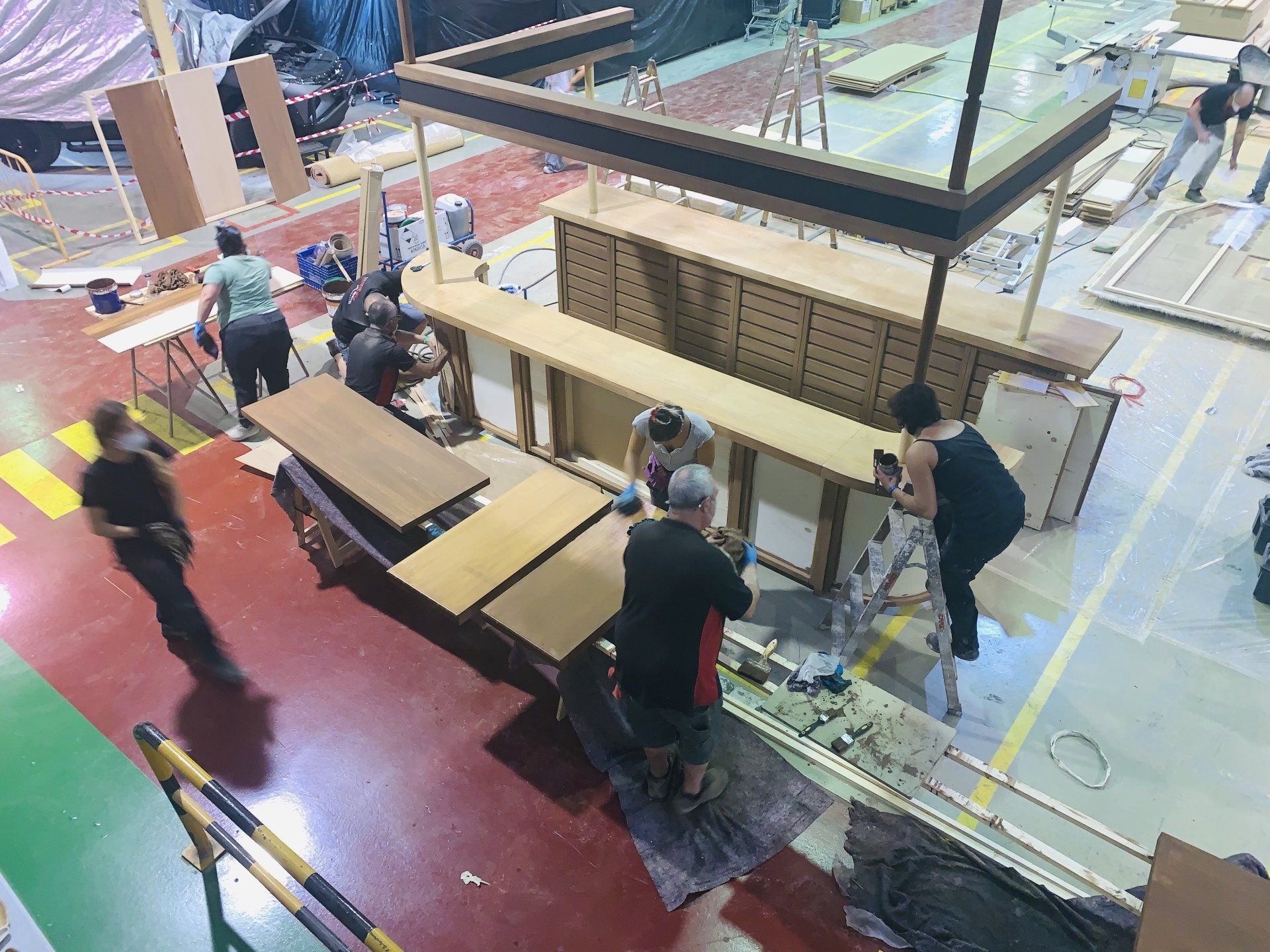 Un grupo de personas está trabajando en una mesa de madera en una fábrica.
