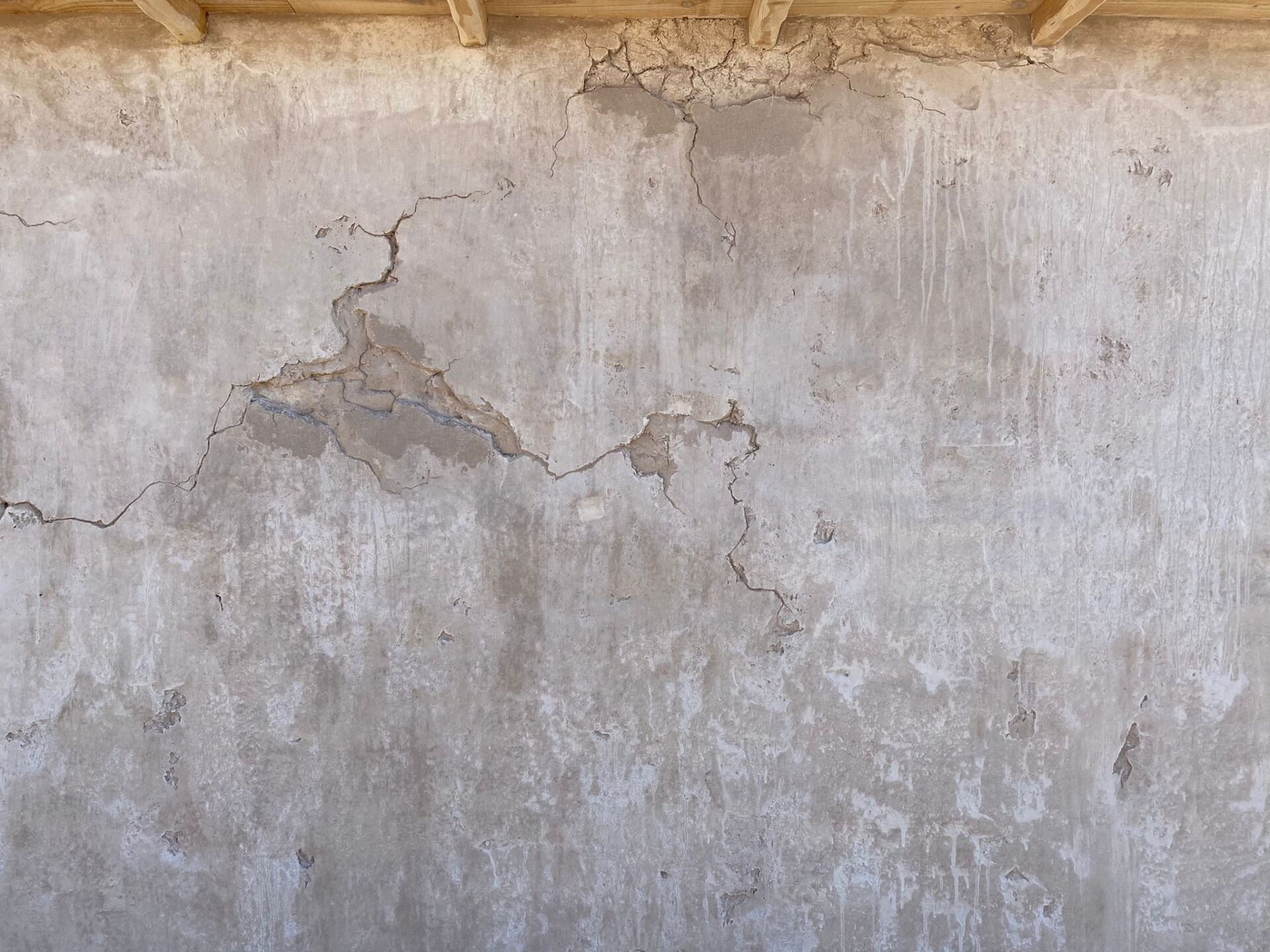 Un primer plano de una pared de hormigón con grietas.