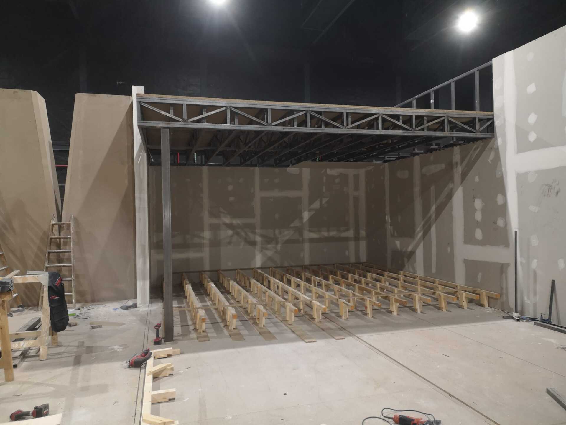 Se está construyendo una gran sala con muchos bancos de madera.