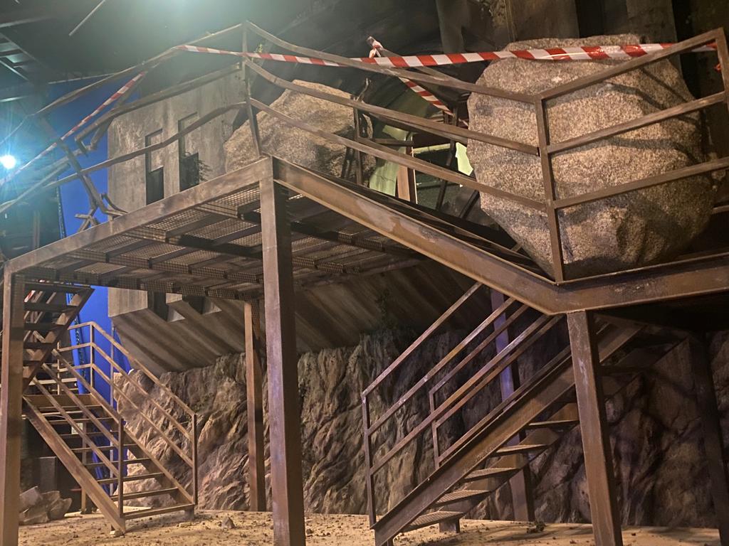 Una gran roca se encuentra encima de una plataforma de metal con escaleras que conducen a ella.