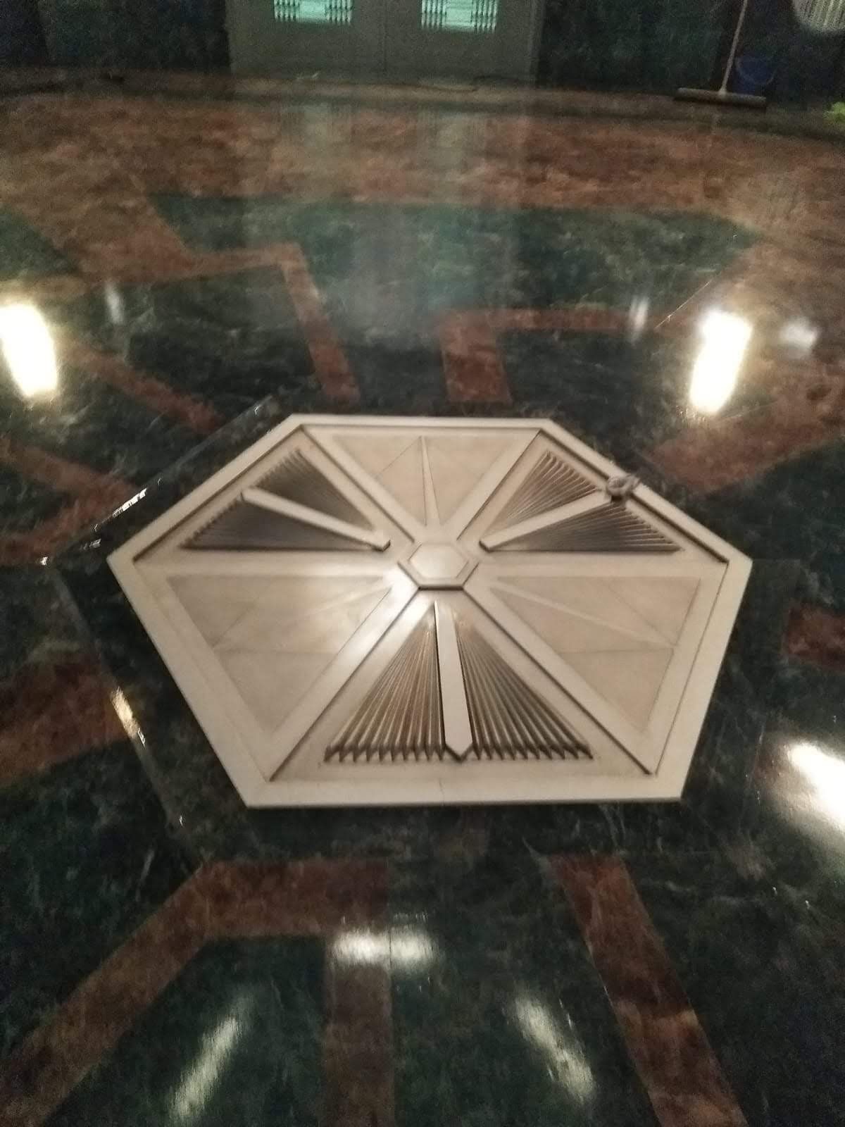 Un objeto con forma hexagonal se encuentra sobre un piso de mármol.