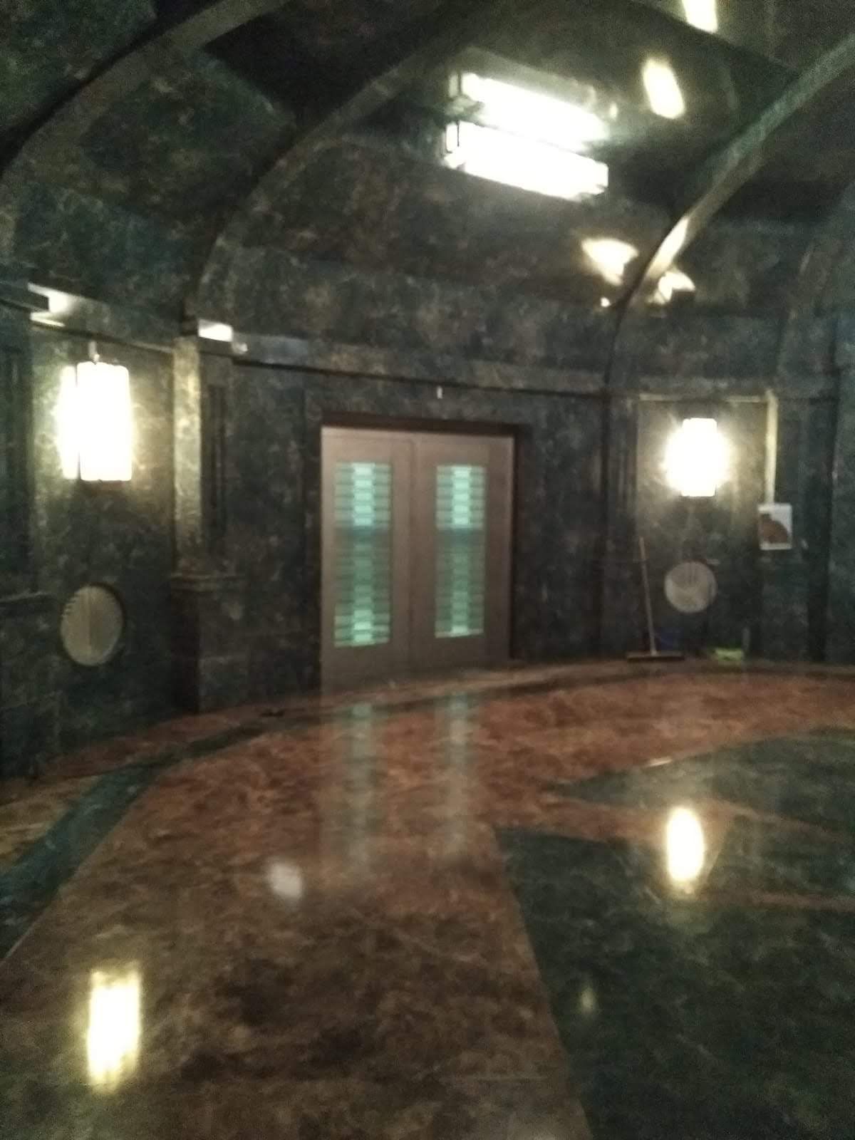 Una habitación oscura con suelo de mármol y una puerta.