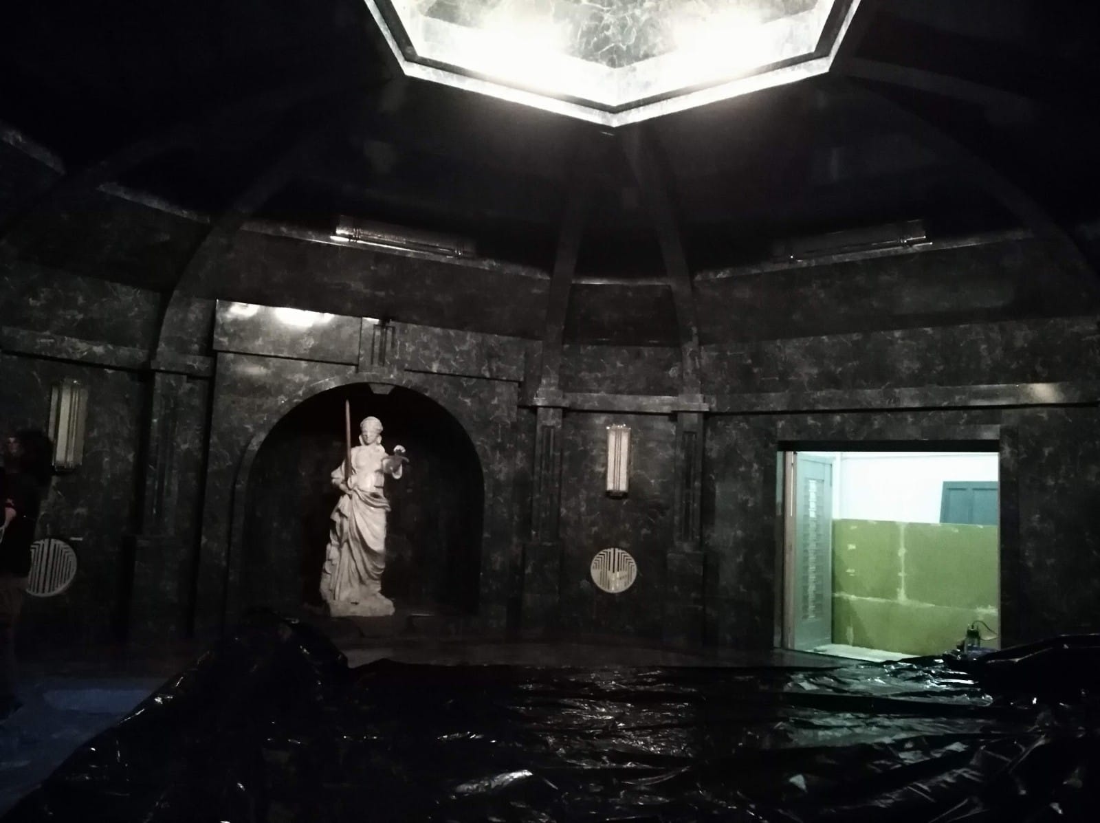 Una habitación oscura con una estatua en el medio.