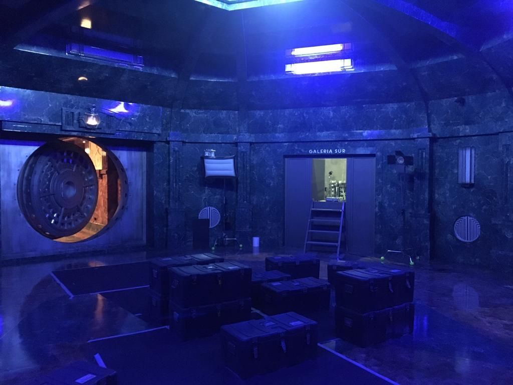 Una habitación oscura con luces azules y una gran puerta bóveda.