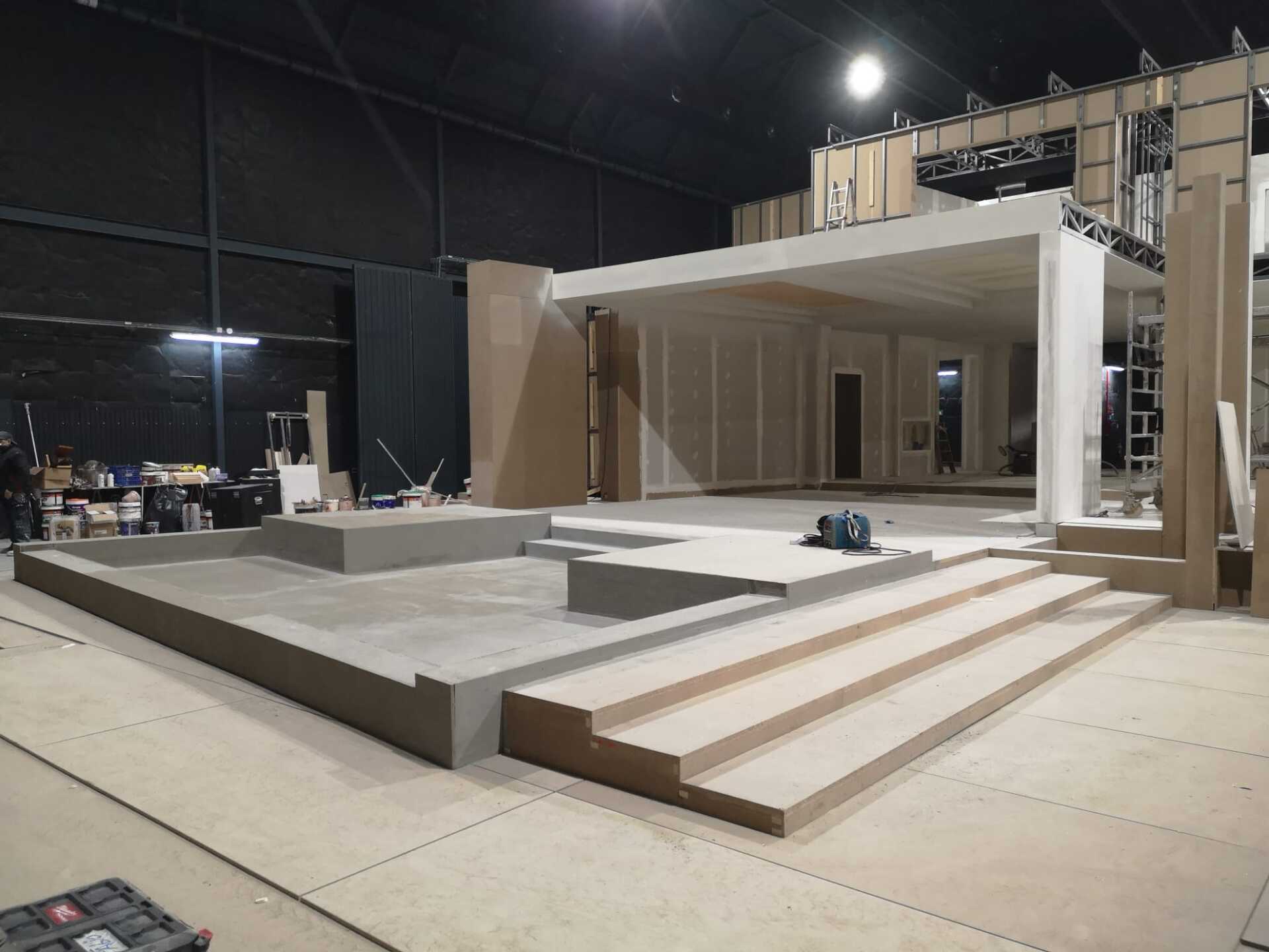 Se está construyendo un escenario en un edificio con escaleras que conducen a él.