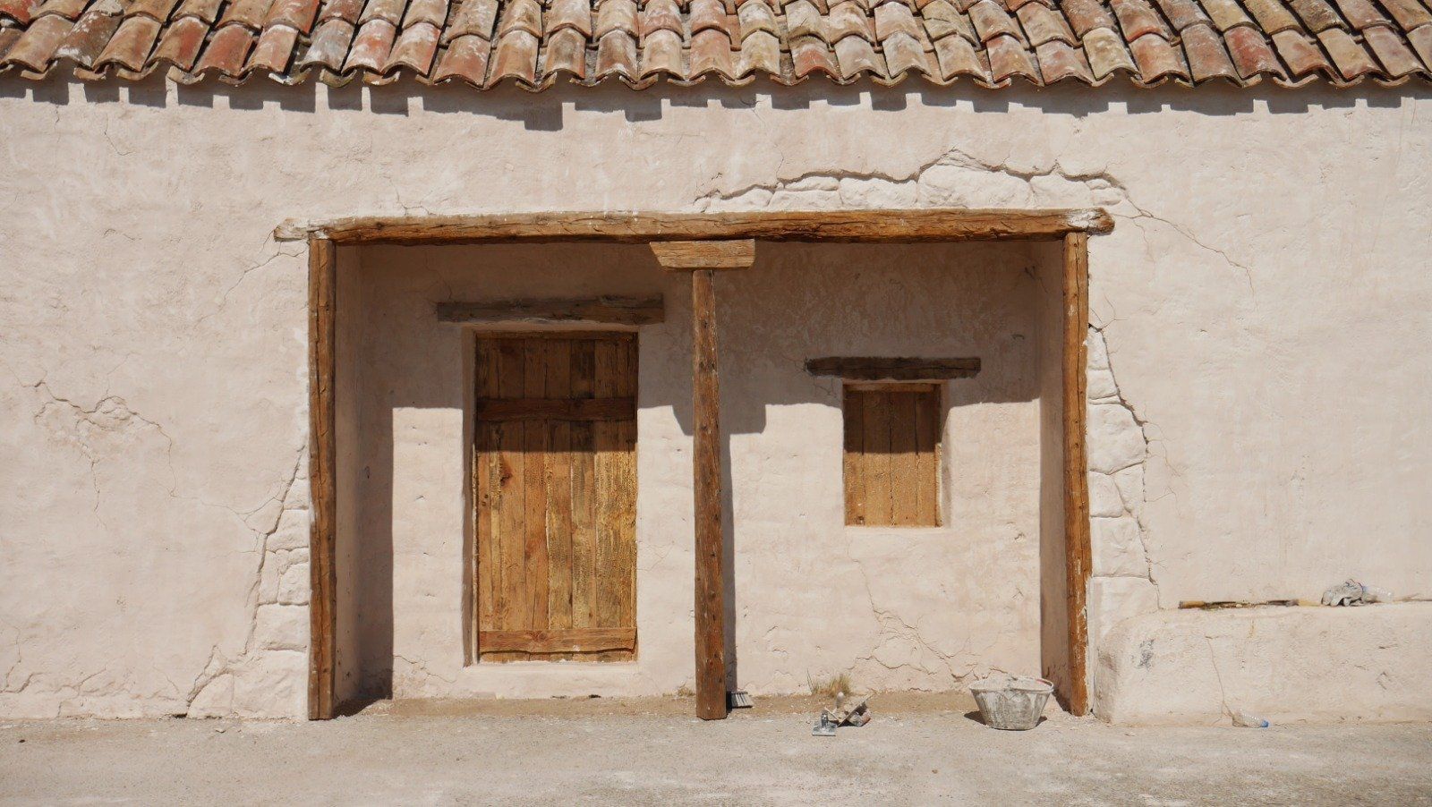 Un edificio blanco con una puerta y una ventana de madera.