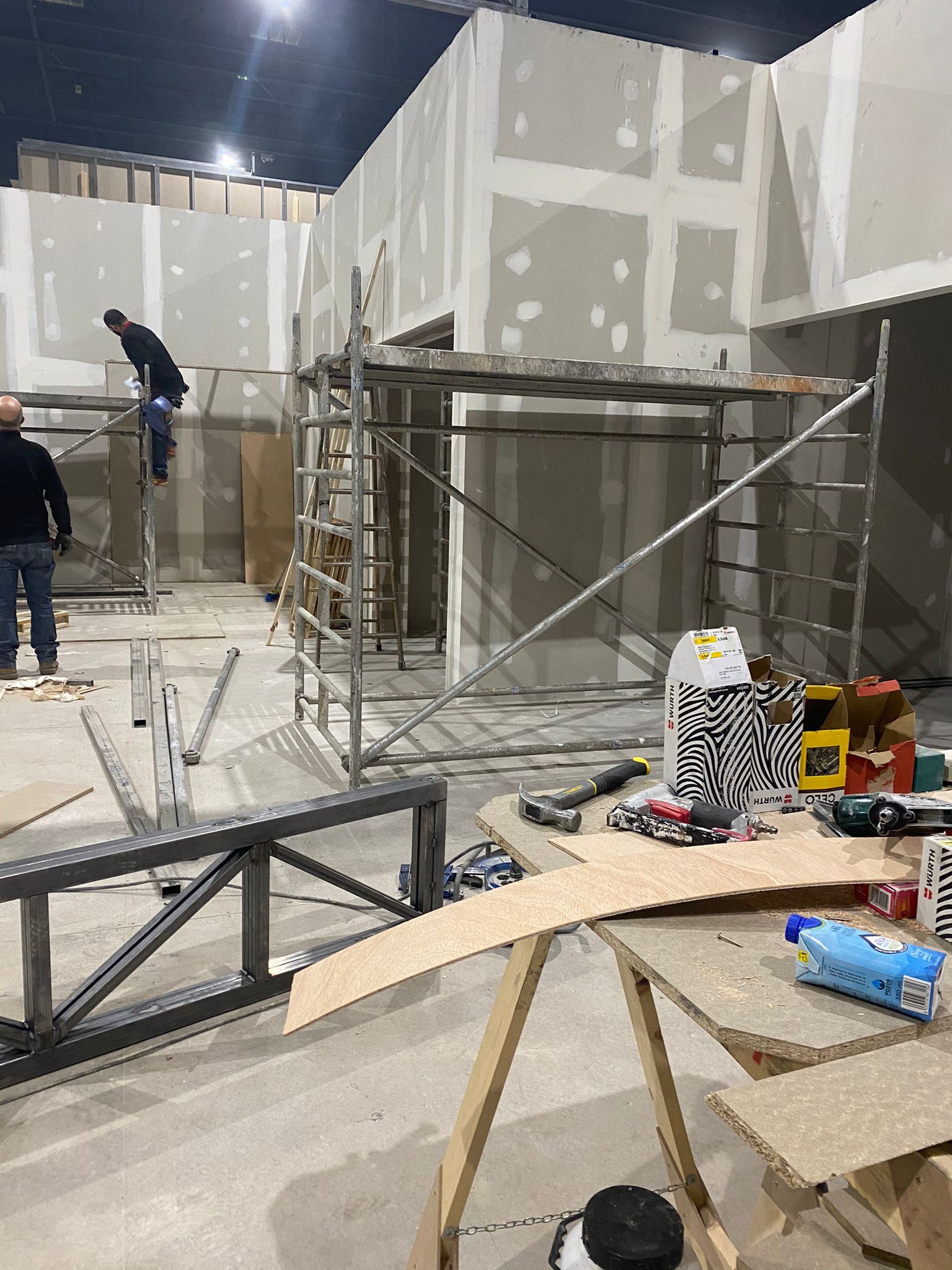 Un hombre está de pie sobre un andamio en una habitación en construcción.