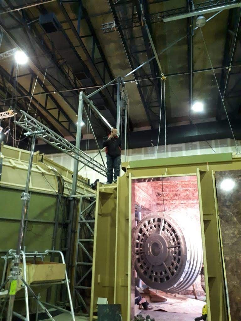 Un hombre está parado encima de una gran máquina en un edificio.