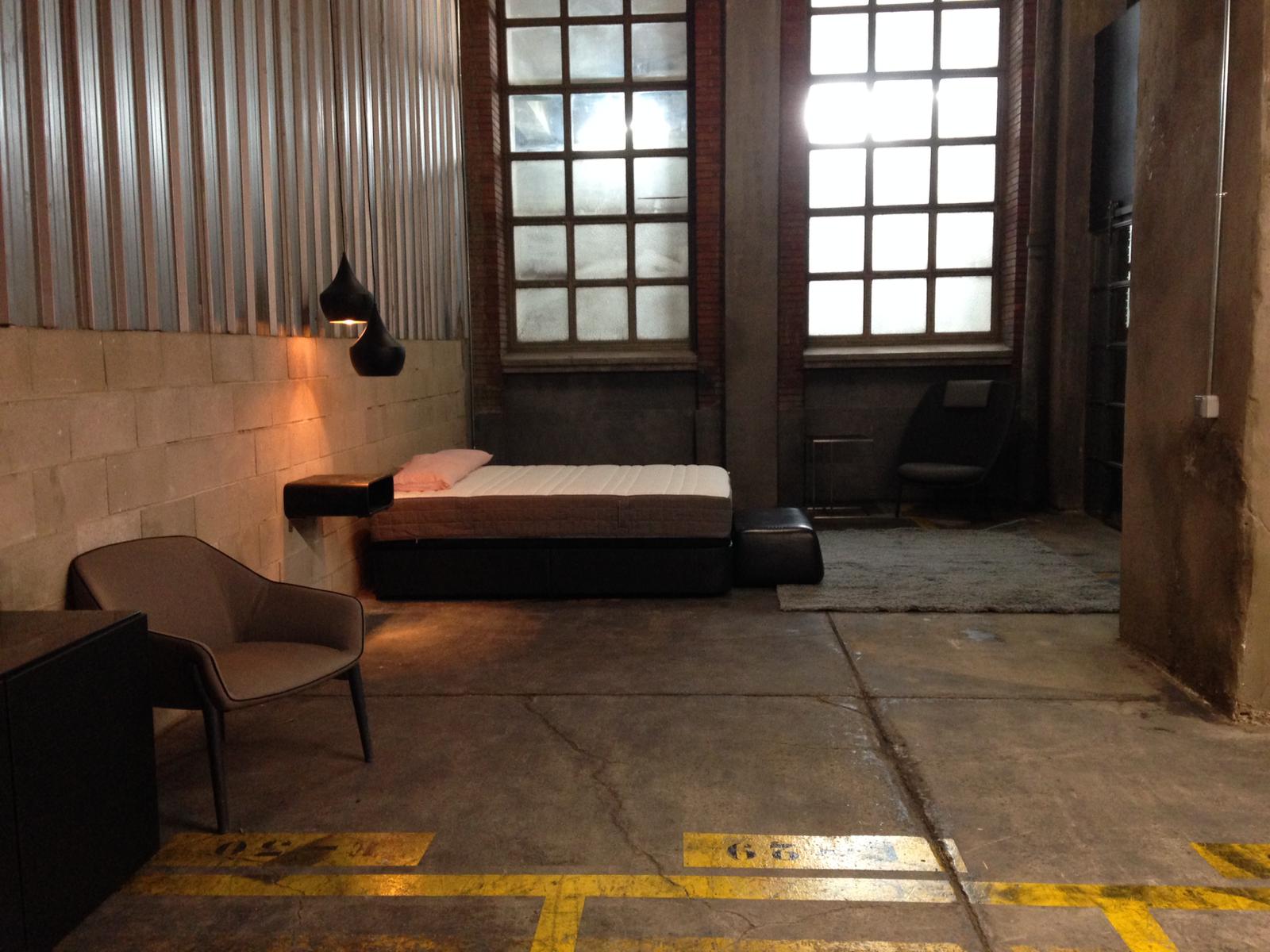 Una habitación con una cama y una silla dentro.