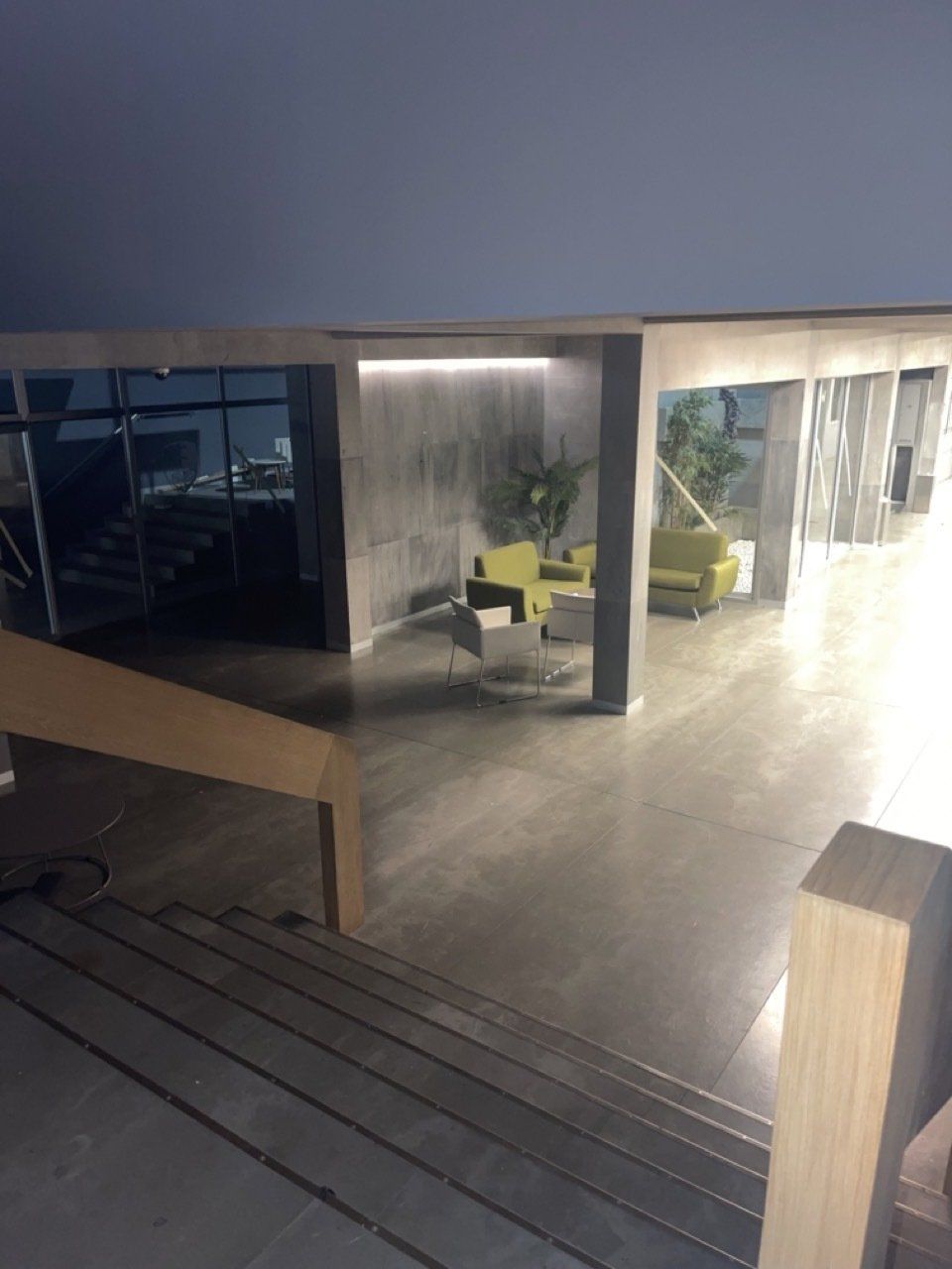 Una escalera que conduce a una sala de estar con un sofá y sillas.