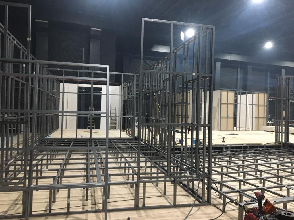 Se está construyendo una gran estructura metálica en una habitación oscura.