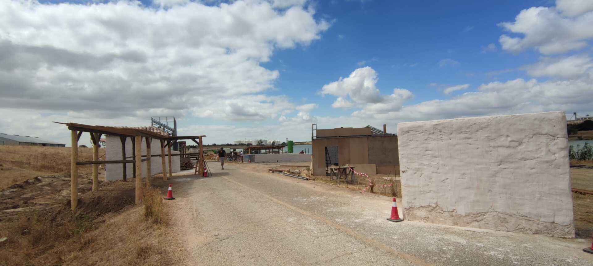 Un camino de tierra con algunos edificios a los lados.