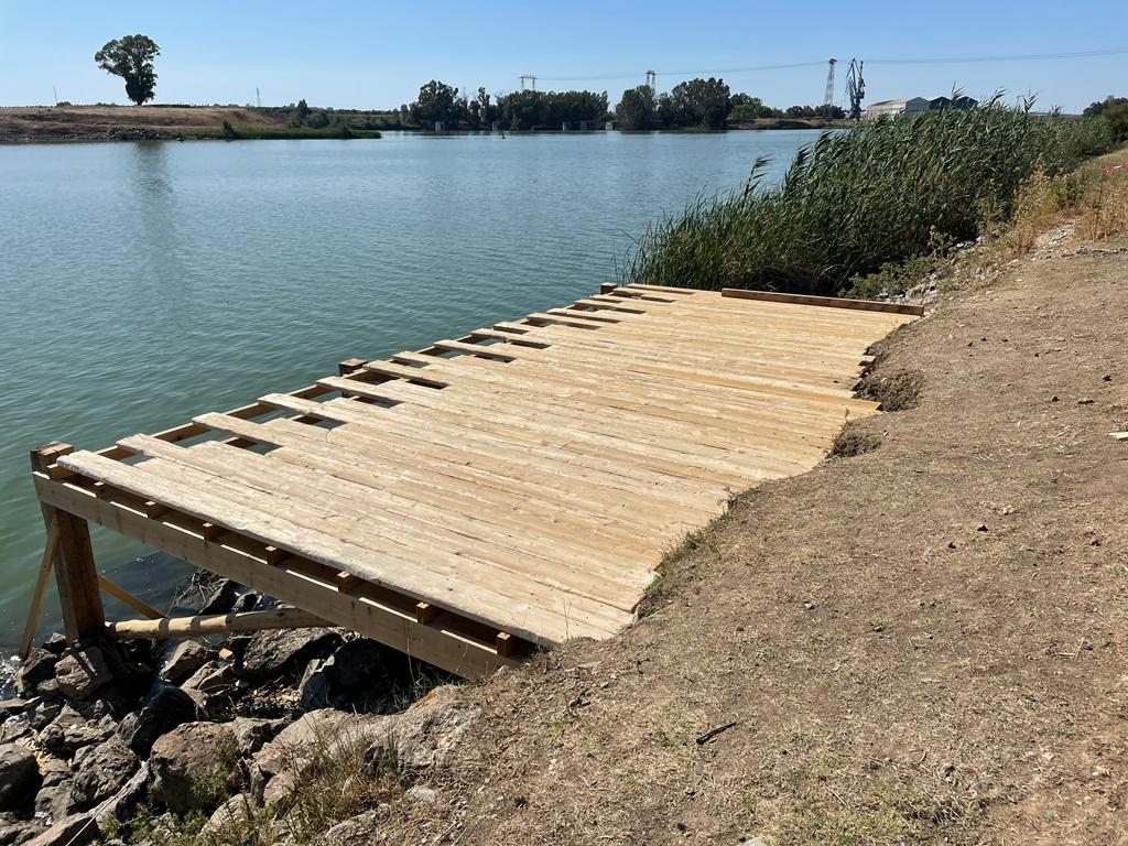 Un muelle de madera está sentado en la orilla de un lago.