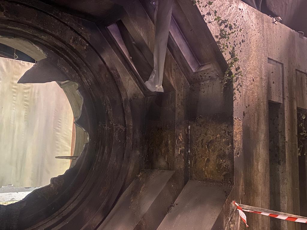 Una persona está parada en el medio de un gran agujero en un edificio.