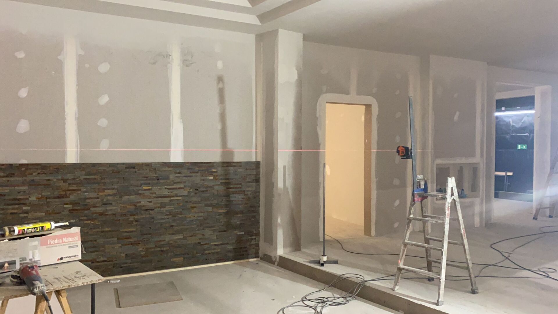 Se está remodelando una habitación con paneles de yeso y una escalera.