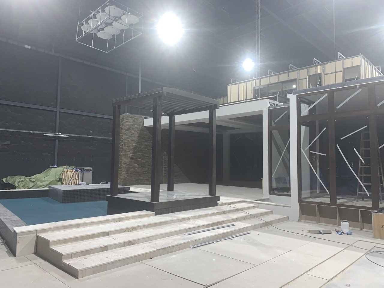 Hay una piscina al fondo y una pérgola en primer plano.