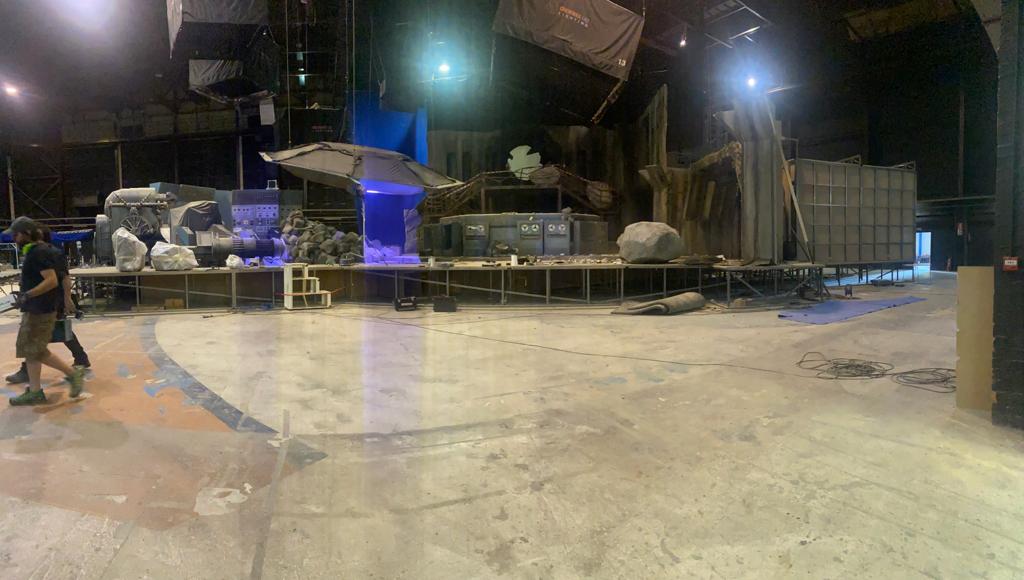 Un par de personas caminan en una habitación vacía por la noche.