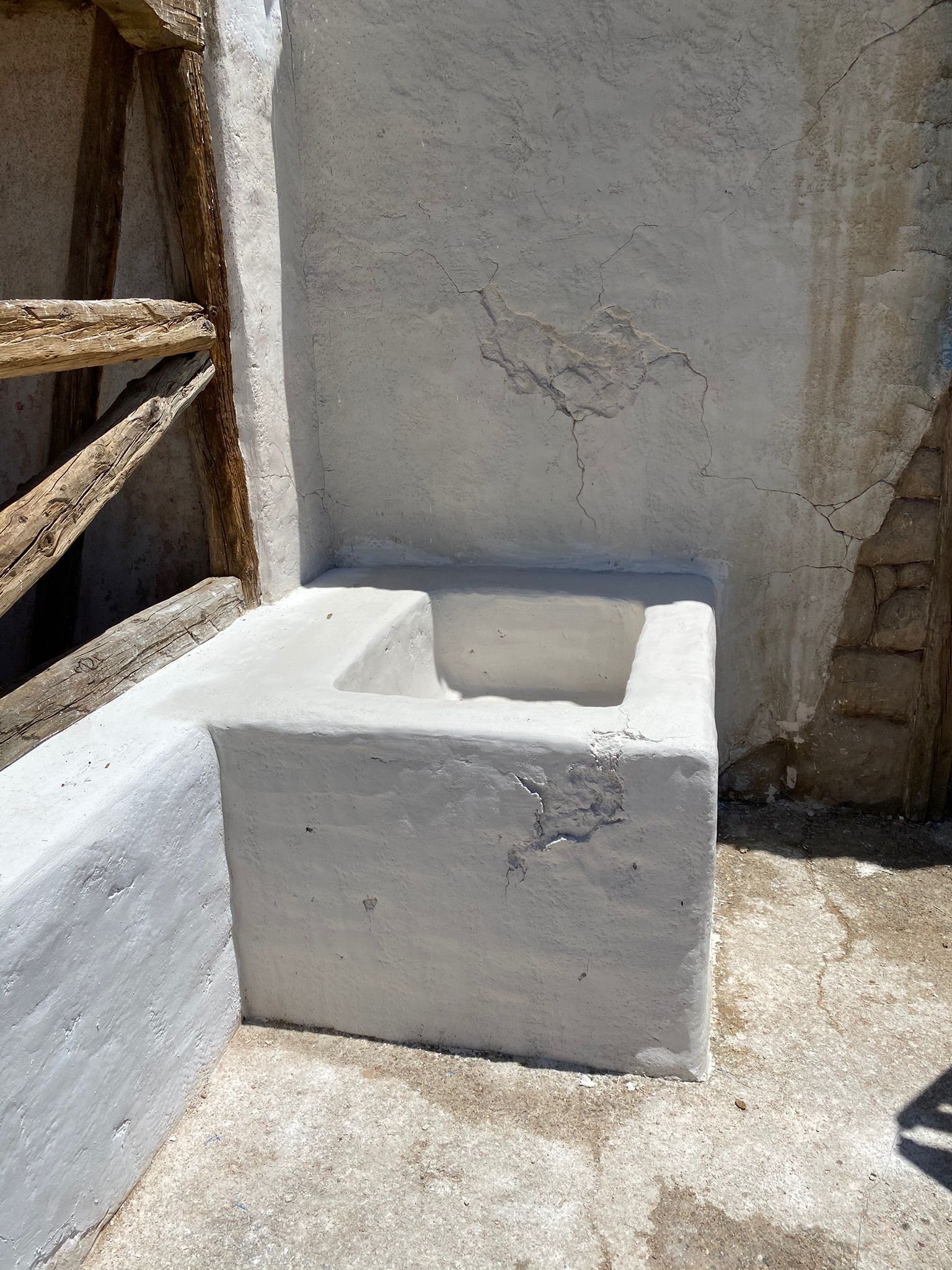 Un bloque de hormigón blanco con un agujero está junto a una pared blanca.