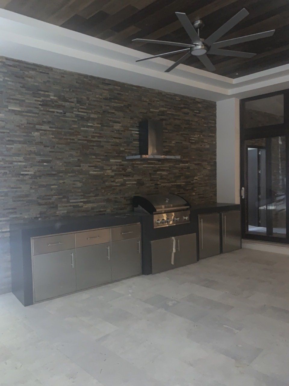 Una cocina con ventilador de techo y una pared de piedra.