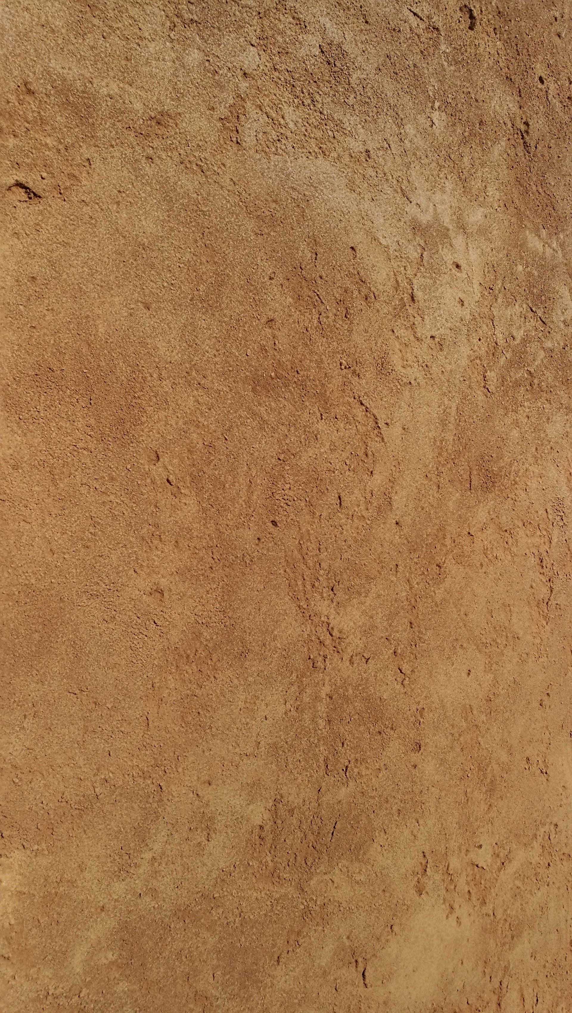 Un primer plano de un azulejo marrón con una textura granulada.