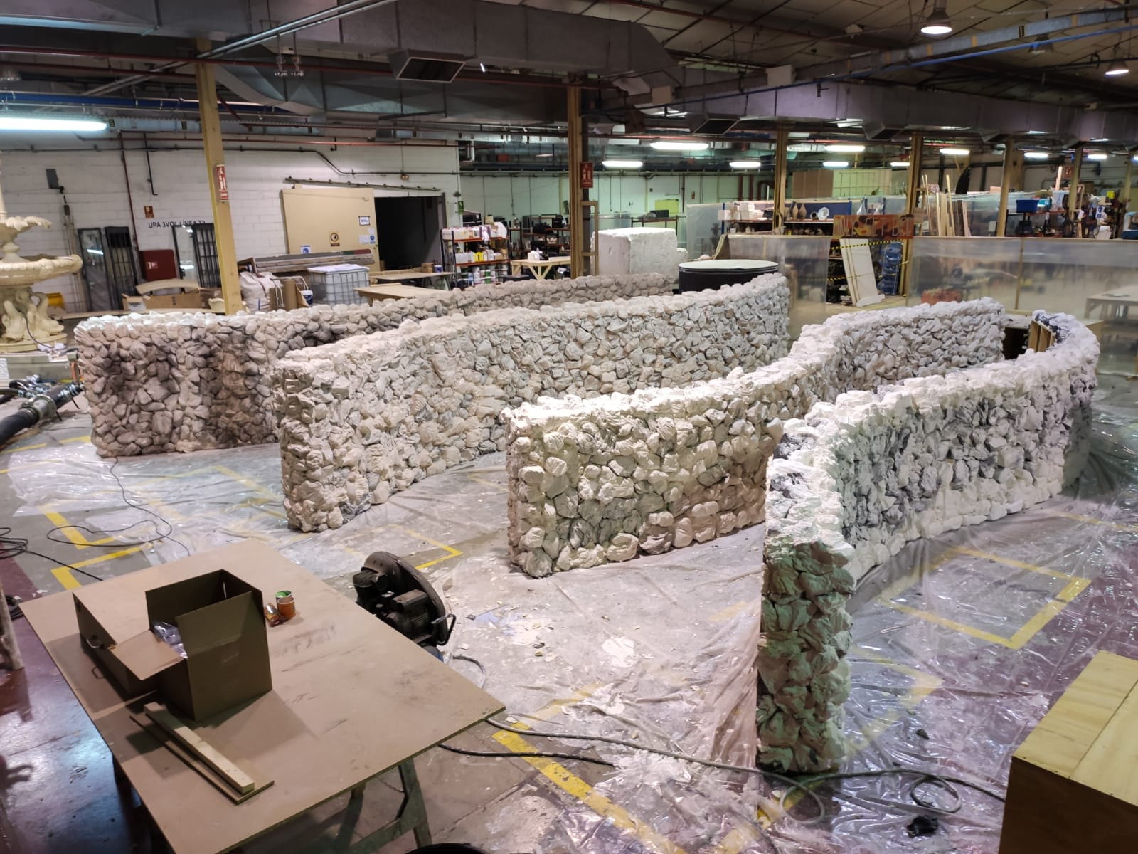 Un gran almacén lleno de muchas cajas y esculturas.