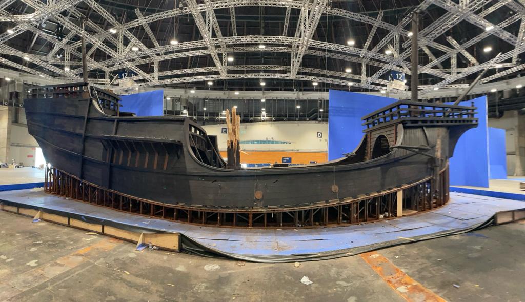 Un modelo de un barco pirata está sentado en un escenario en una sala grande.