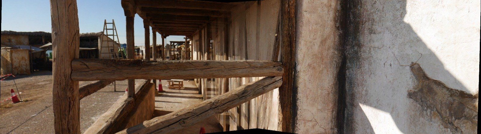 La sombra de una persona se proyecta sobre una pared frente a un edificio en construcción.