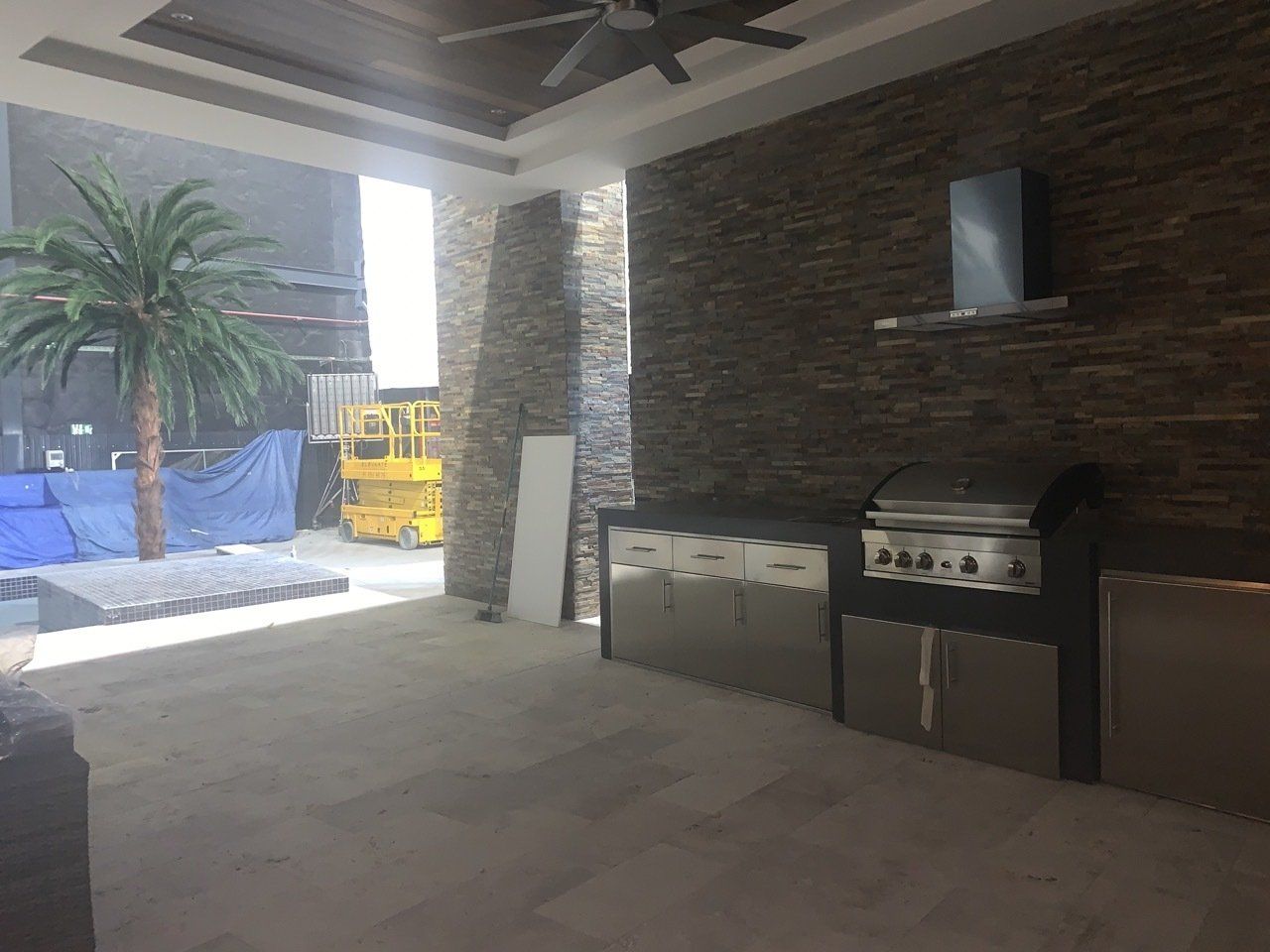 Una habitación vacía con una parrilla y un ventilador de techo.