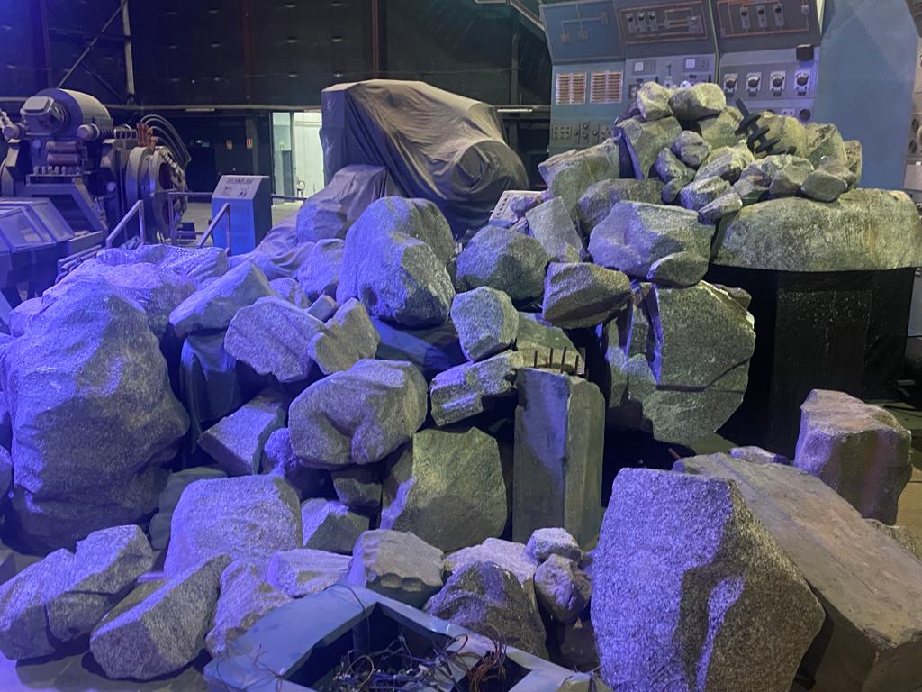 Un montón de rocas está en el suelo delante de una máquina.