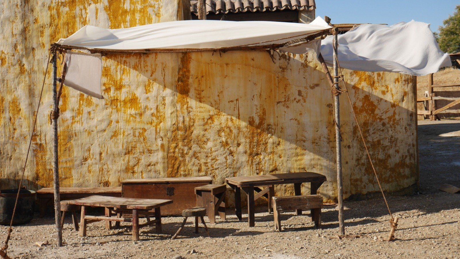 Una pequeña carpa con mesas y sillas debajo.
