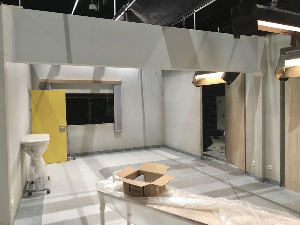 Una habitación vacía con una puerta amarilla y una caja sobre una mesa.