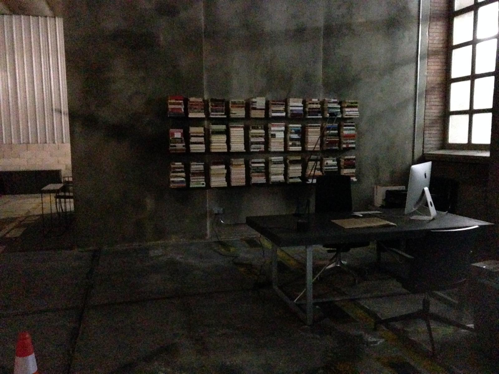 Una habitación oscura con un escritorio y una computadora encima.