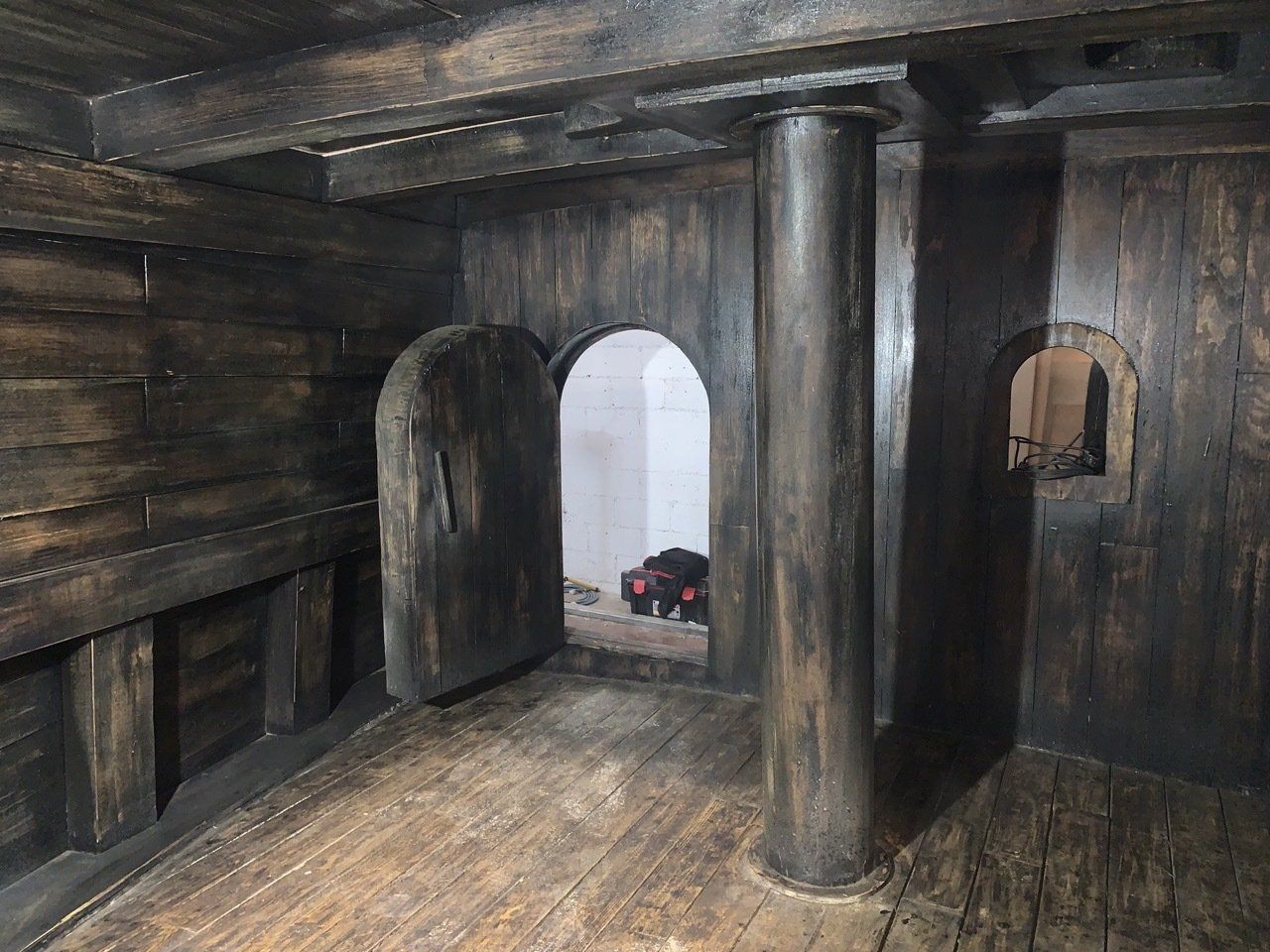 Una habitación de madera con columnas y arcos.