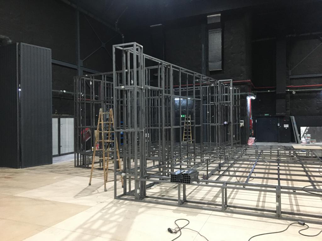 Se está construyendo una gran estructura metálica en una sala grande.