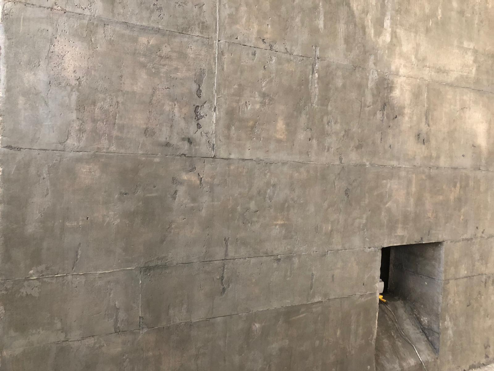 Un primer plano de una pared de hormigón con un agujero en ella.