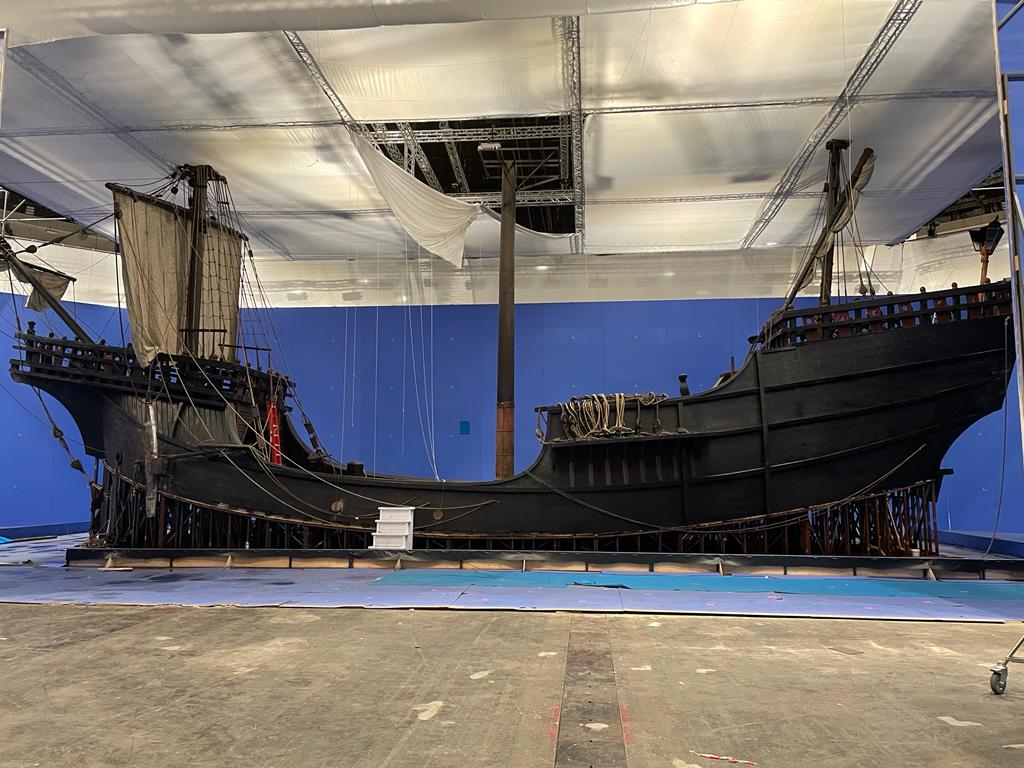 Un modelo de un barco pirata está sentado en una habitación con un fondo azul.