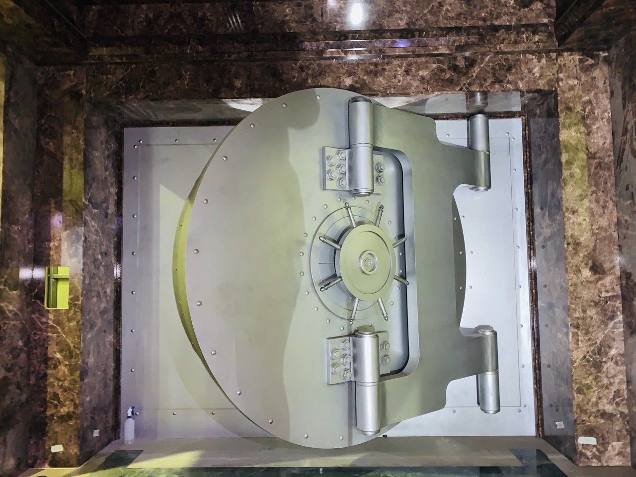 Una puerta de bóveda se encuentra encima de un piso de mármol.