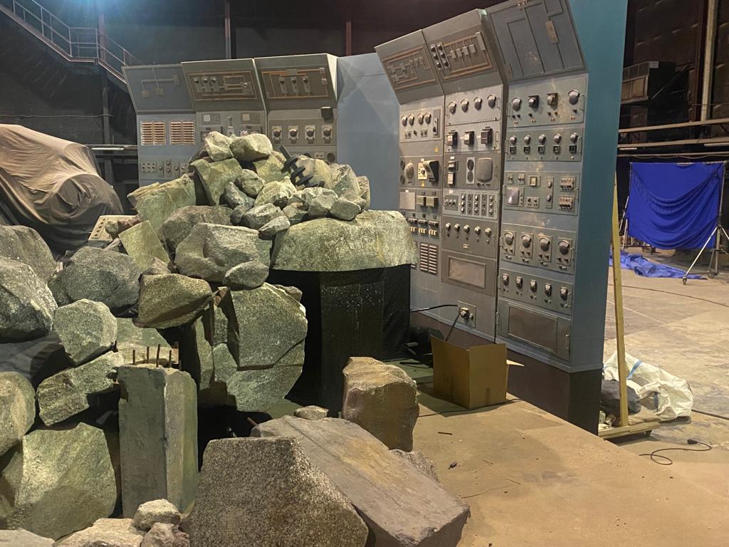 Una pila de rocas se encuentra frente a un panel de control en un almacén.