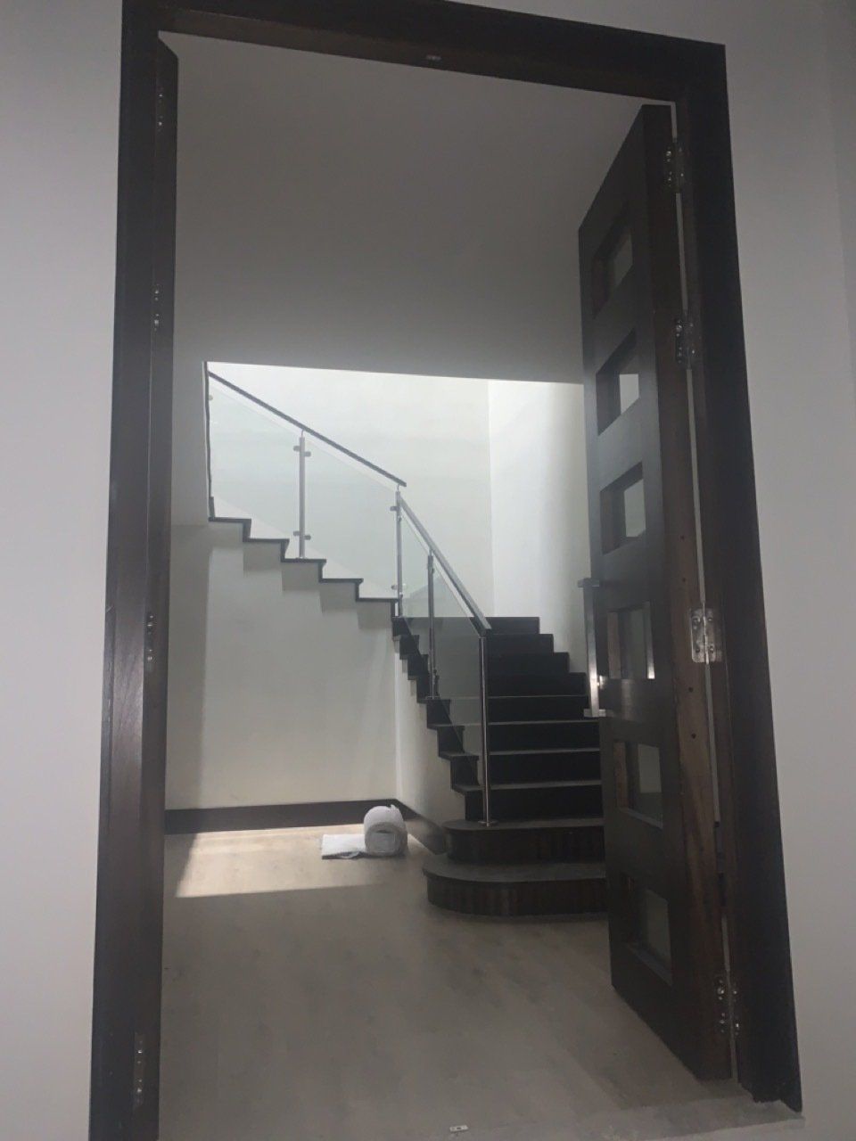 Una puerta que conduce a una escalera con barandilla de vidrio.