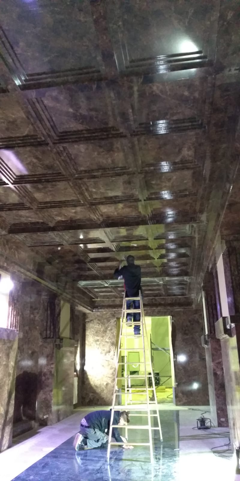 Un hombre está de pie en una escalera en una habitación.